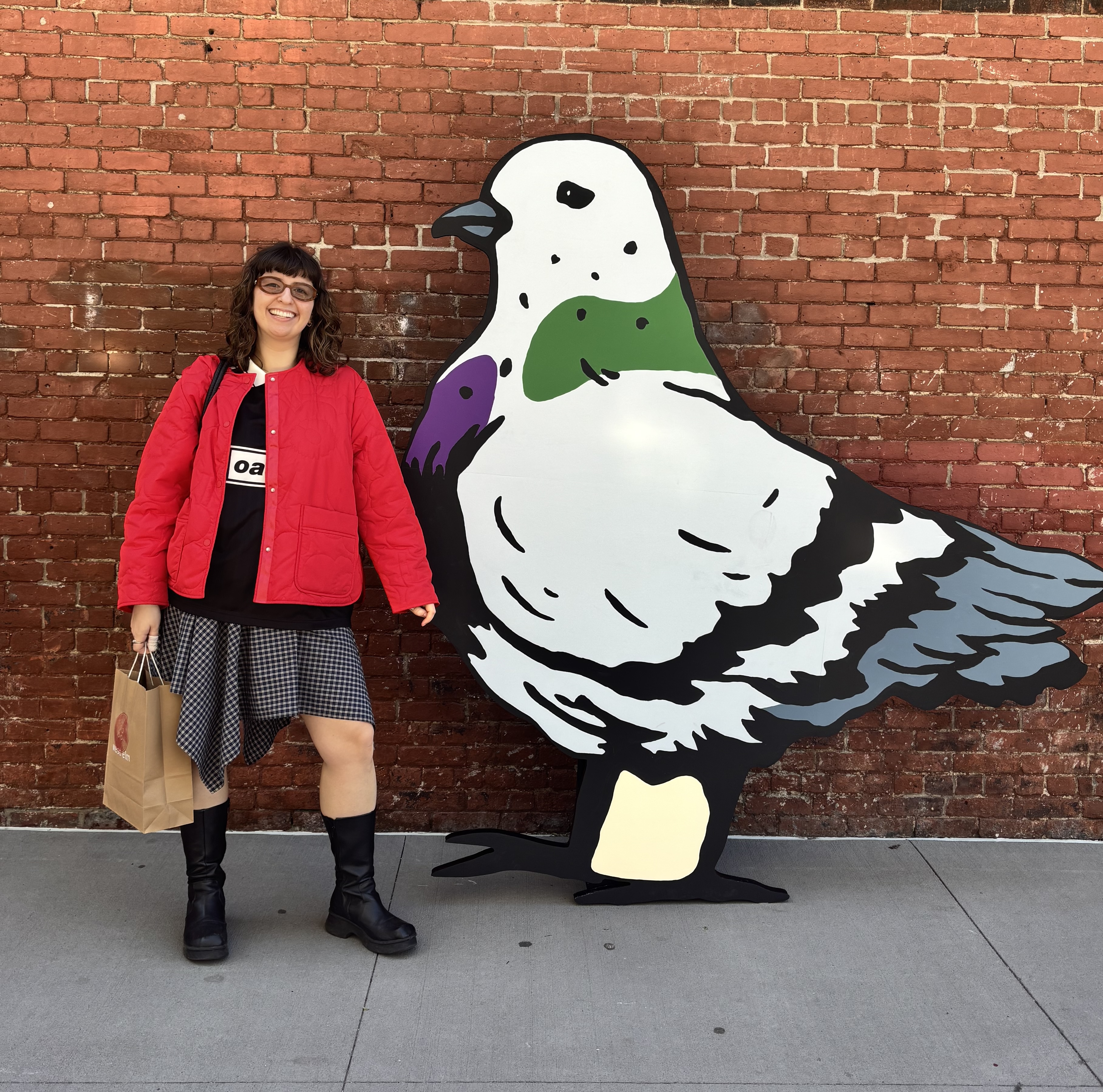Natalie poses with a larger-than-life pigeon standee 