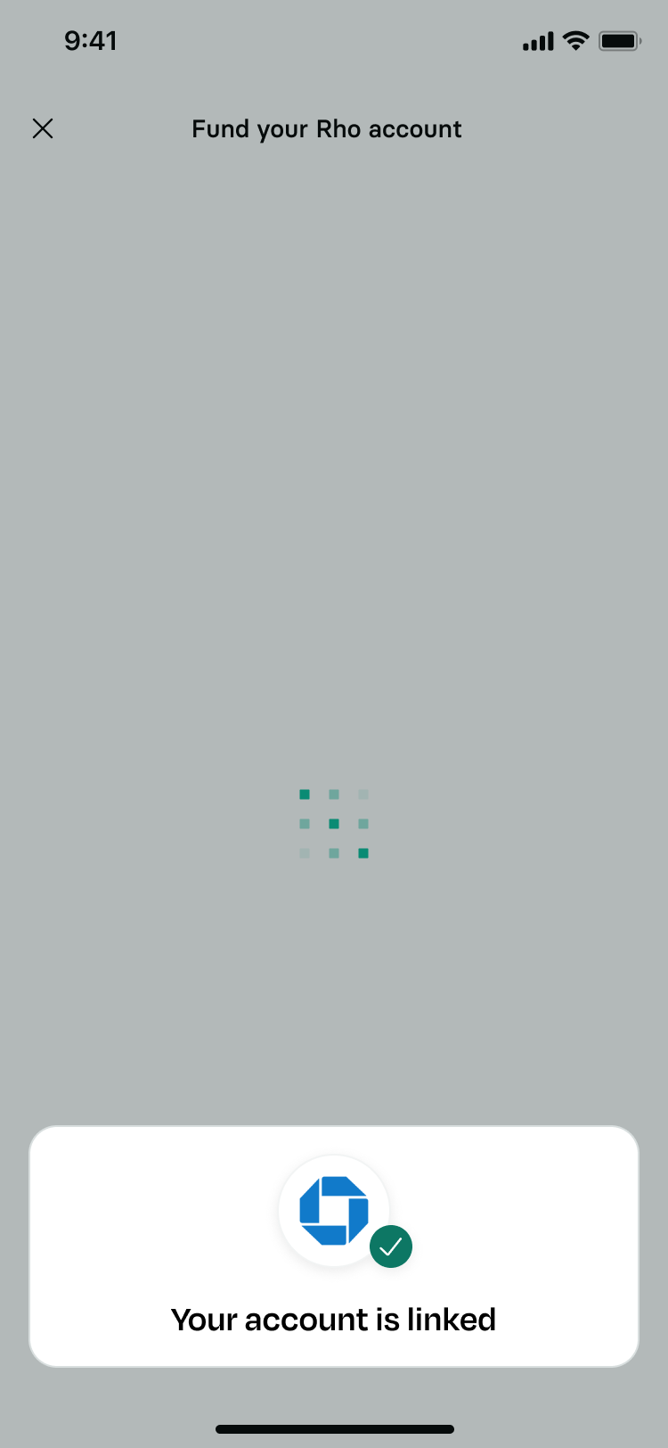 A mobile banking status interface with a dimmed grey background showing a loading animation at its center. A white notification card pops up at the bottom containing a blue Chase bank logo with a green checkmark badge, accompanied by clear bold text reading Your account is linked.